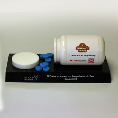 Medical prescription pills spilling out of custom shaped bottle on base award or gift